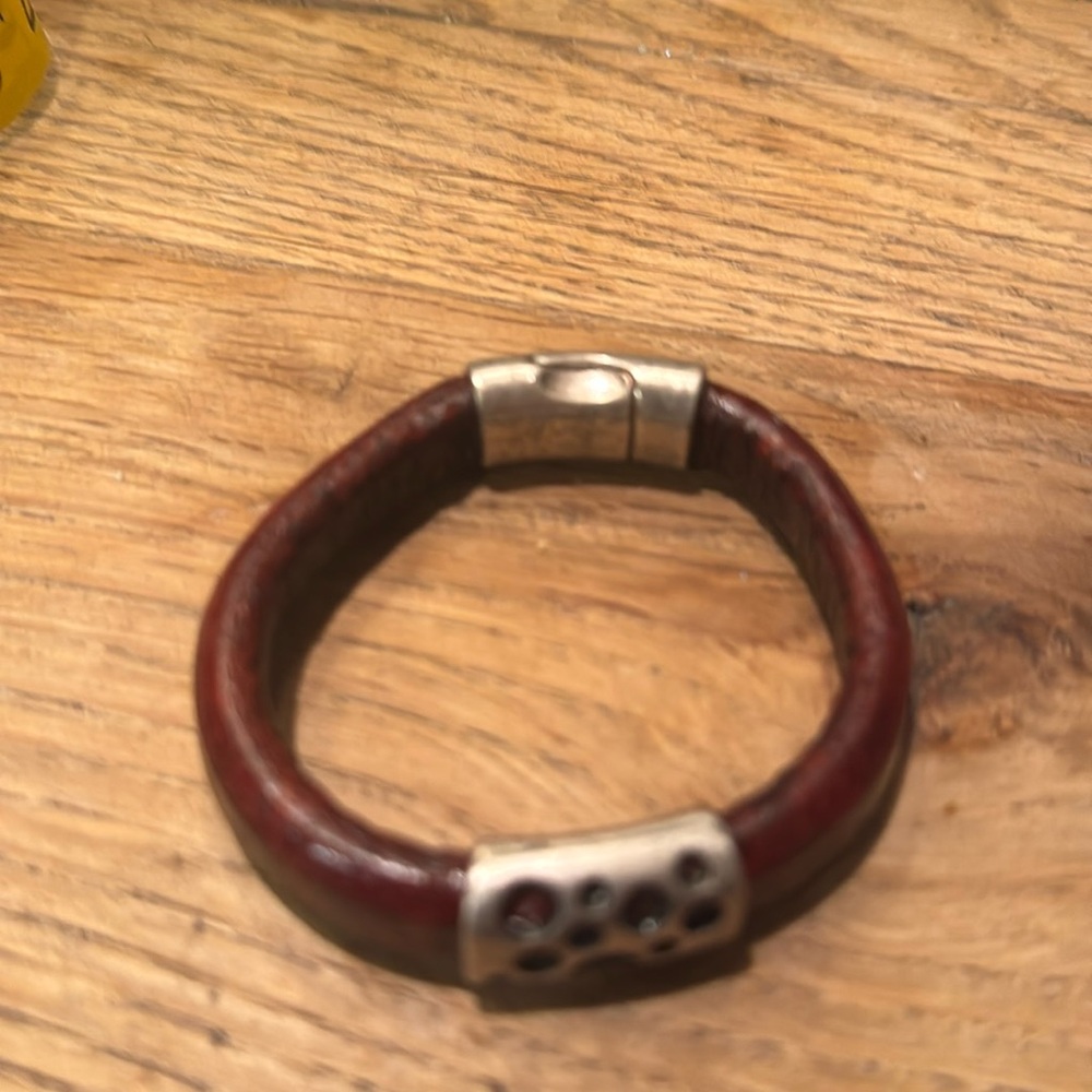 Handmade leather cuff bracelet with silver embellishments.